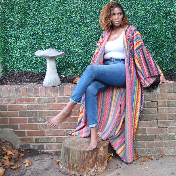 A woman models a luxury Japanese kimono robe with bold multicolored stripes in primary hues, made from medium-weight knit fabric for a stylish, comfortable look.