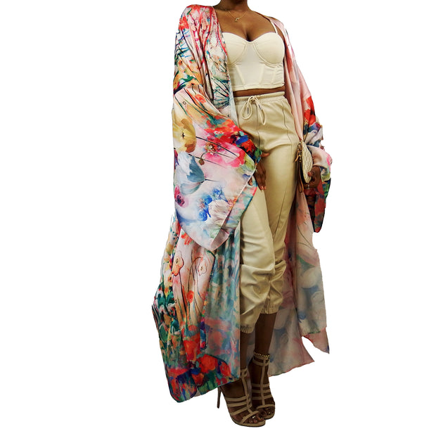 wildflowers decorate the palette of this floor length kimono in shades of light pink, red blue and green pictured hered worn over beige clothing