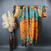 Green copper and gold kimono with flower petal pattern hung on bamboo rod