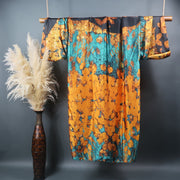 Green and gold kimono duster robe displayed hanging on bamboo rod