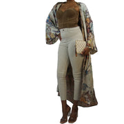 woam wearing a kimono robe in muted flowered tones and nude beige and taupe colors worn with clear heeled sandals