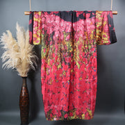 floor length kimono robe pictured from the back hanging on a bamboo display rod pink black and gold