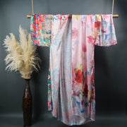 flowers printed on a long length kimono duster robe hanging from a bamboo display bar